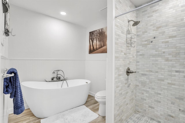 bathroom featuring toilet, hardwood / wood-style flooring, and independent shower and bath