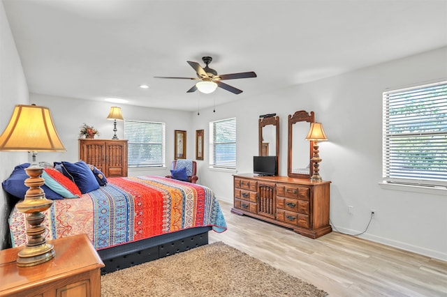 bedroom with light hardwood / wood-style flooring, multiple windows, and ceiling fan