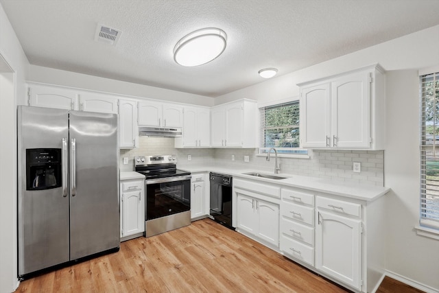 kitchen featuring light hardwood / wood-style floors, appliances with stainless steel finishes, sink, and white cabinets