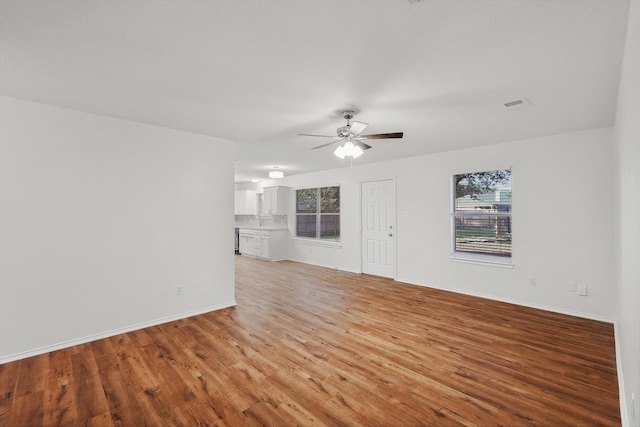 unfurnished living room featuring light wood-type flooring and ceiling fan