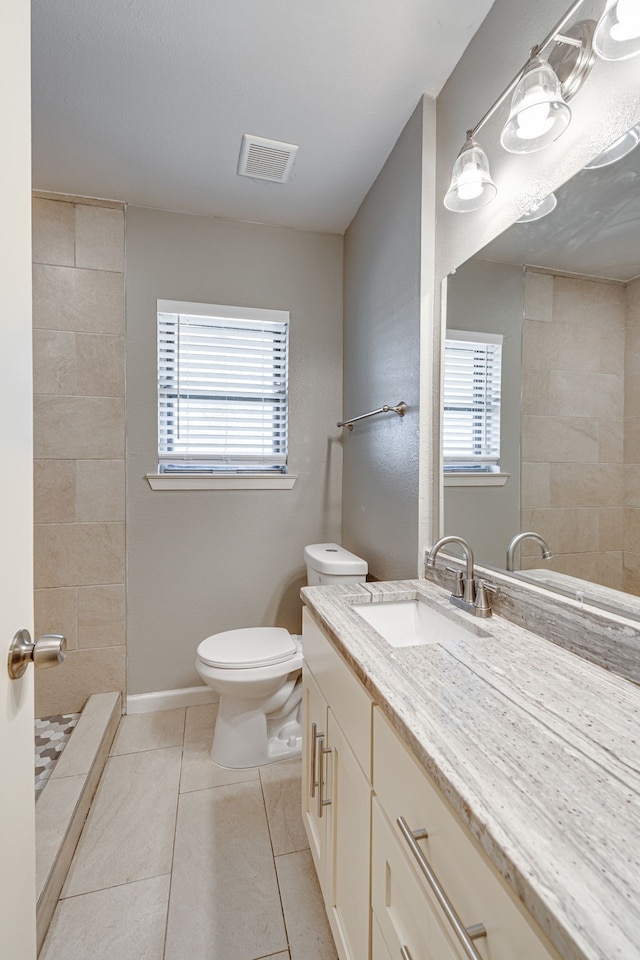 bathroom featuring vanity, toilet, tile patterned floors, and plenty of natural light