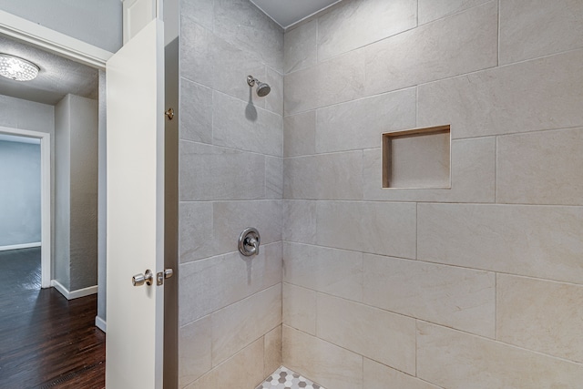 bathroom featuring a tile shower and hardwood / wood-style floors