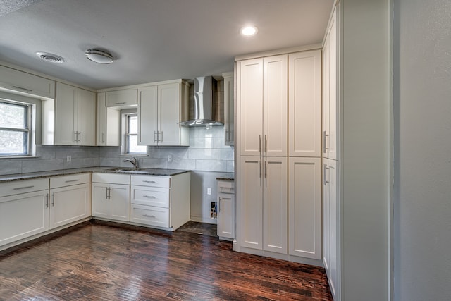 kitchen featuring white cabinetry, wall chimney range hood, and dark hardwood / wood-style flooring