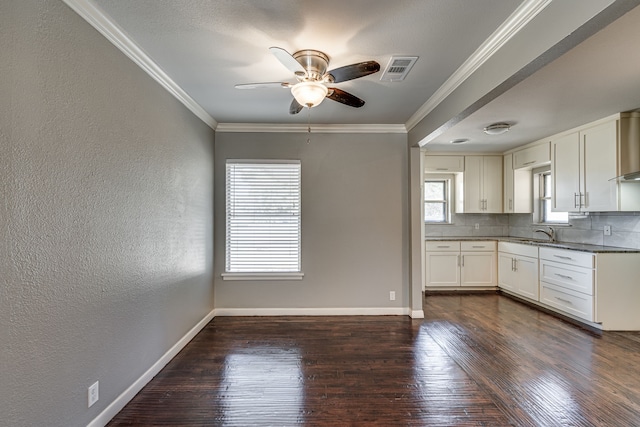 kitchen with crown molding, dark hardwood / wood-style floors, and white cabinets