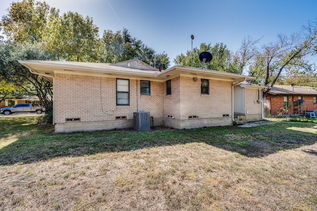 rear view of house with a yard and cooling unit