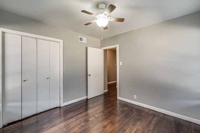 unfurnished bedroom featuring dark wood-type flooring, ceiling fan, and a closet