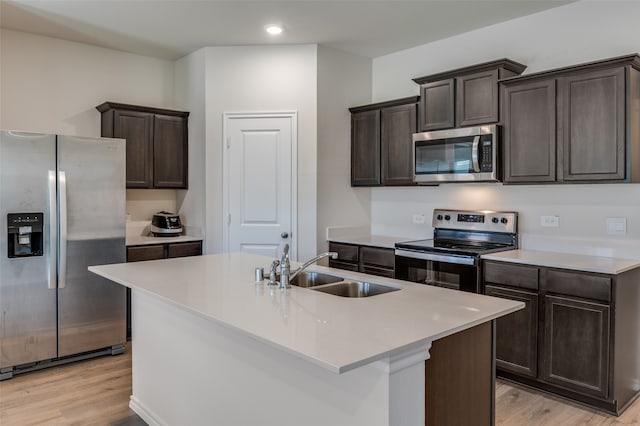 kitchen with a center island with sink, sink, light hardwood / wood-style flooring, and stainless steel appliances