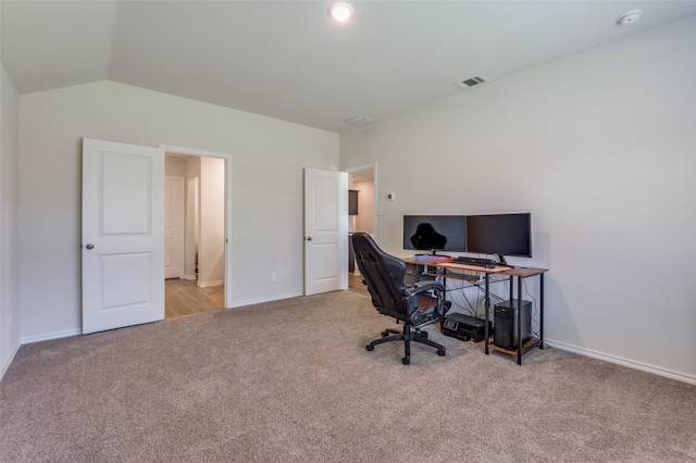 carpeted home office featuring lofted ceiling