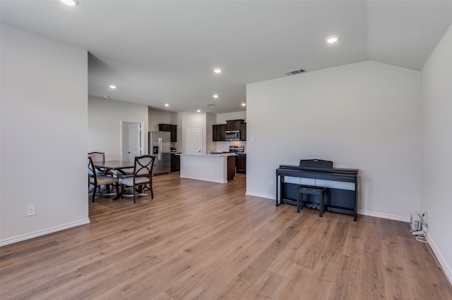 living room featuring light hardwood / wood-style floors and vaulted ceiling