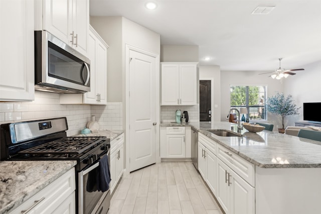 kitchen featuring light stone countertops, sink, appliances with stainless steel finishes, and white cabinets