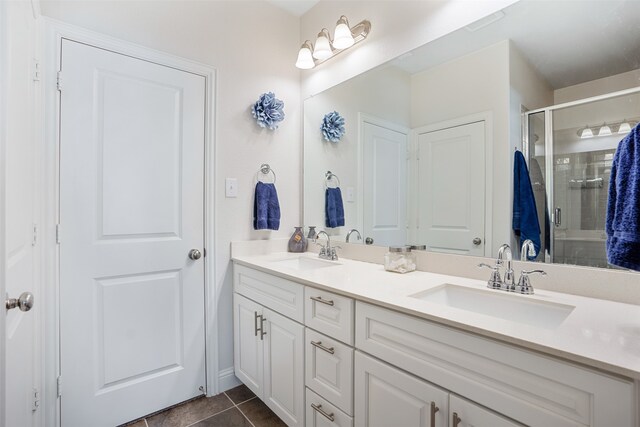 bathroom featuring a shower with door, tile patterned floors, and vanity