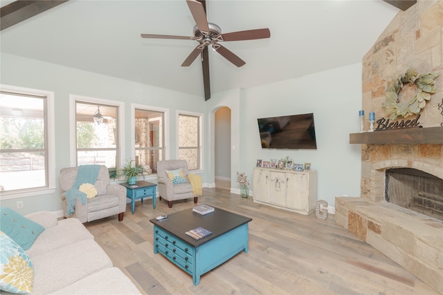 living room featuring light hardwood / wood-style floors, vaulted ceiling with beams, and a fireplace