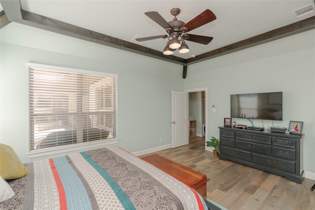 bedroom with ceiling fan, beam ceiling, and light hardwood / wood-style flooring