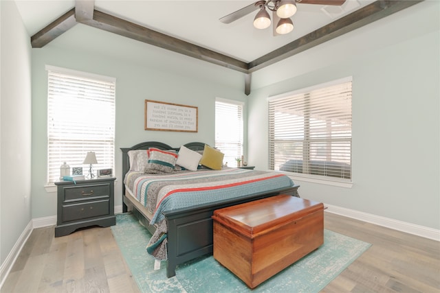 bedroom with beamed ceiling, wood-type flooring, and ceiling fan