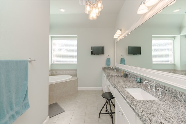 bathroom with vanity, tile patterned floors, tiled tub, and a wealth of natural light