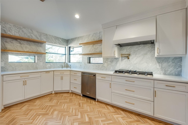 kitchen with white cabinets, decorative backsplash, premium range hood, and stainless steel appliances