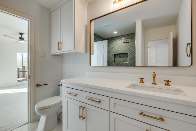 bathroom with vanity, a shower, ceiling fan, toilet, and a fireplace