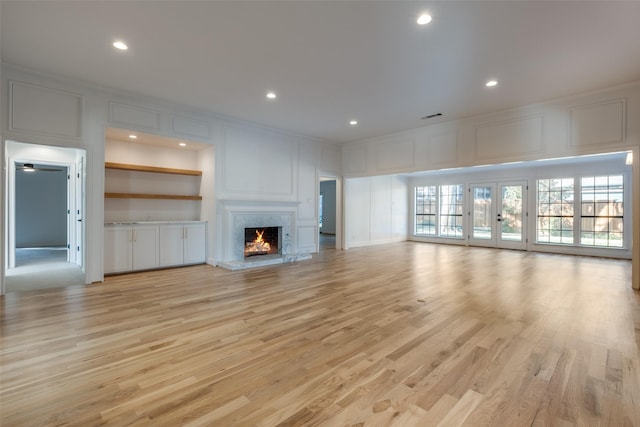 unfurnished living room featuring light hardwood / wood-style floors and a premium fireplace