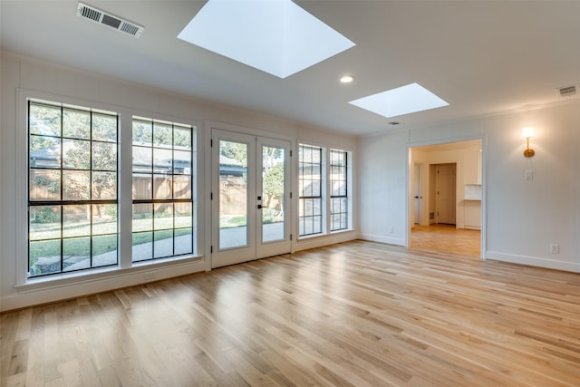 interior space featuring ornamental molding, a skylight, french doors, and light hardwood / wood-style floors