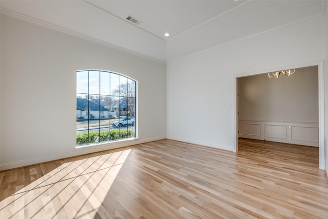 empty room featuring ornamental molding and light hardwood / wood-style flooring