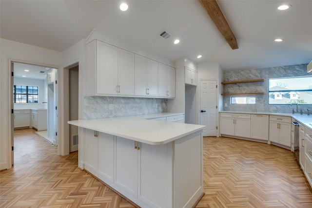 kitchen featuring white cabinetry, kitchen peninsula, light parquet floors, a breakfast bar area, and decorative backsplash