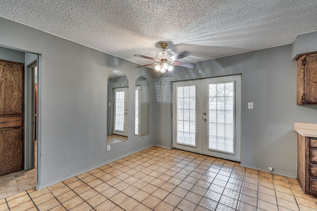 interior space featuring french doors, a textured ceiling, ceiling fan, and light tile patterned flooring