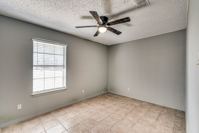 tiled spare room featuring a textured ceiling and ceiling fan