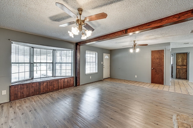 216 W Marshall St, Palmer, TX 75152 - spare room featuring ceiling fan, beamed ceiling, a textured ceiling, and wood finished floors