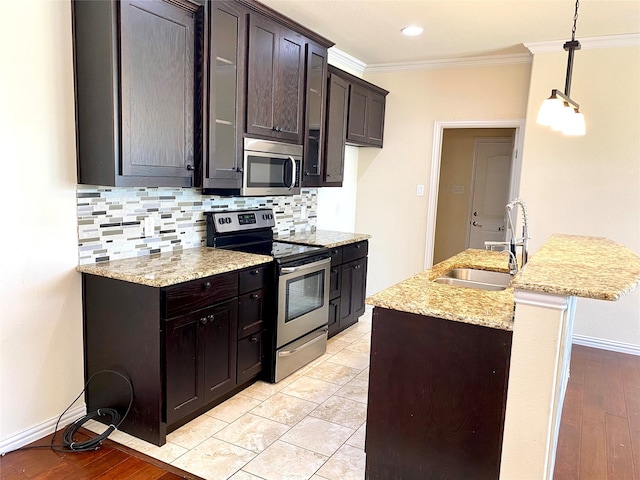 kitchen with sink, dark brown cabinets, hanging light fixtures, light hardwood / wood-style floors, and stainless steel appliances