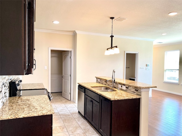 kitchen featuring light hardwood / wood-style flooring, hanging light fixtures, stainless steel appliances, an island with sink, and sink