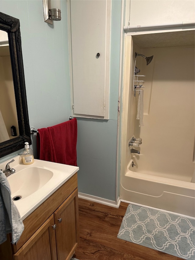 bathroom with  shower combination, vanity, and hardwood / wood-style floors