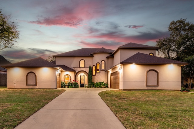 mediterranean / spanish-style house with a lawn and a garage