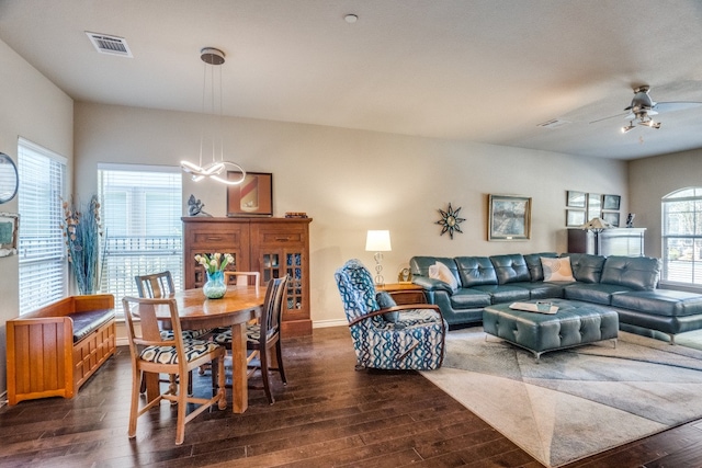 dining space with ceiling fan and dark hardwood / wood-style flooring