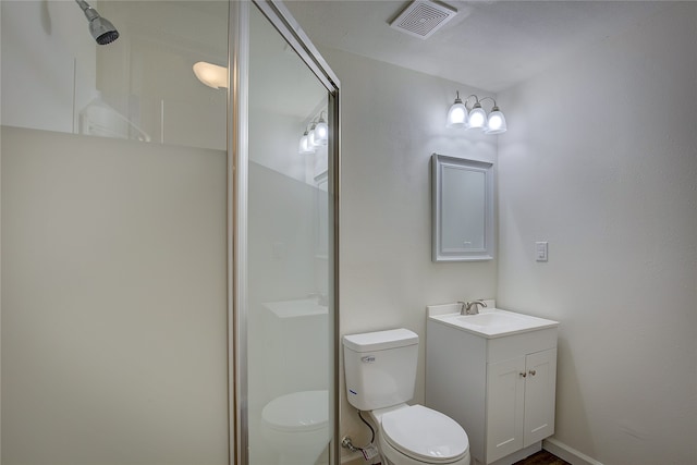 bathroom featuring vanity, toilet, and an enclosed shower