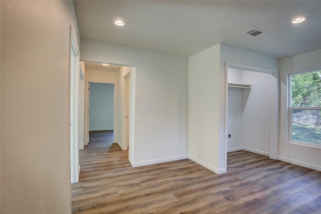 unfurnished bedroom with a closet and dark hardwood / wood-style flooring