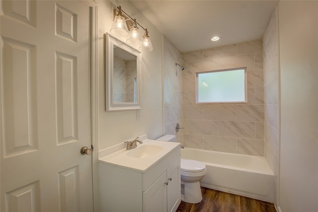 full bathroom with toilet, tiled shower / bath combo, hardwood / wood-style flooring, and vanity