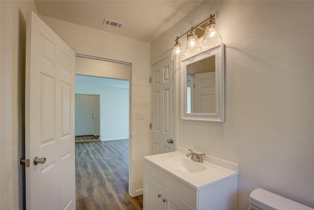 bathroom featuring vanity, toilet, and hardwood / wood-style flooring