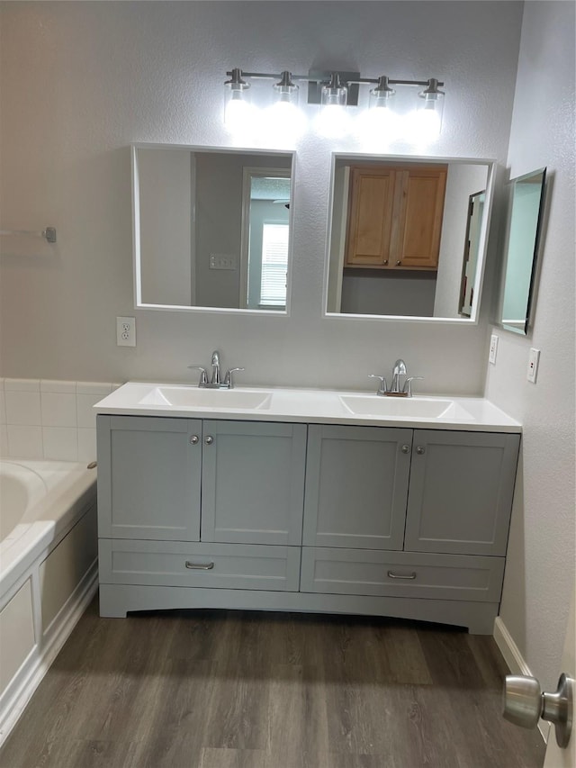 bathroom featuring wood-type flooring, a bath, and vanity