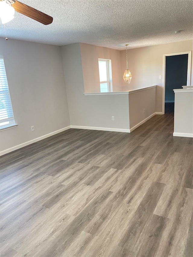 spare room featuring dark hardwood / wood-style flooring, a textured ceiling, plenty of natural light, and ceiling fan