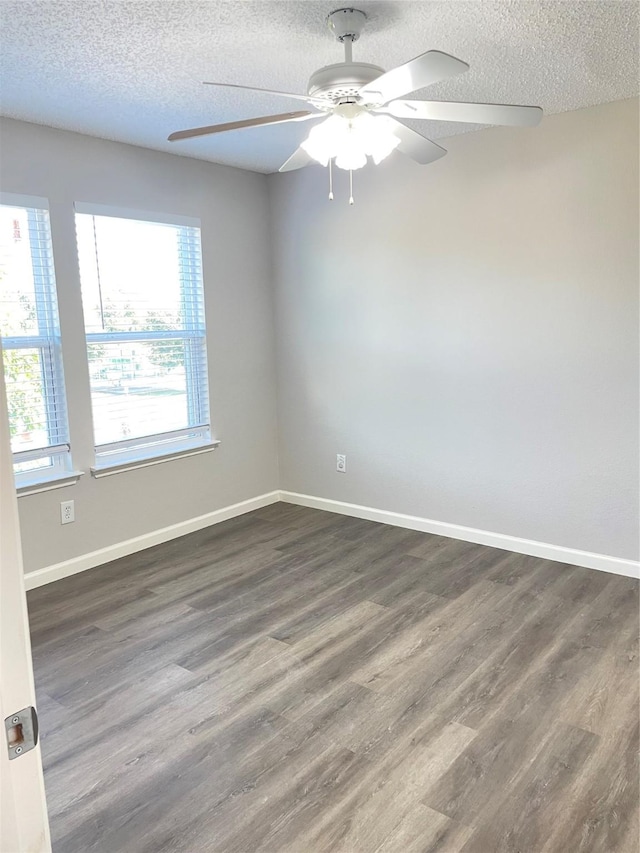 unfurnished room with ceiling fan, dark hardwood / wood-style floors, and a textured ceiling