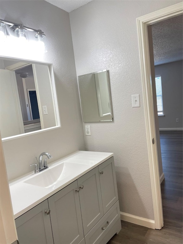 bathroom featuring wood-type flooring, vanity, and a textured ceiling