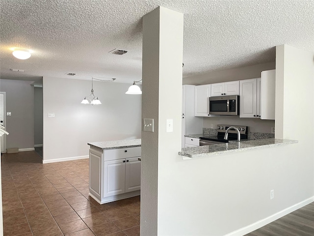 kitchen featuring hanging light fixtures, white cabinetry, appliances with stainless steel finishes, and kitchen peninsula