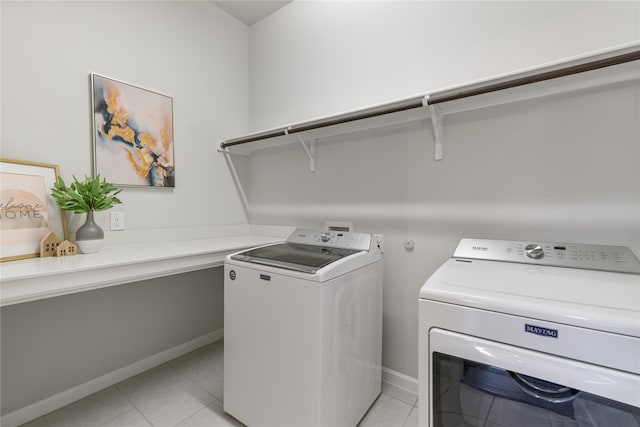 laundry area with independent washer and dryer and light tile patterned floors