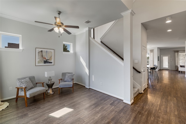 sitting room featuring dark wood-type flooring, ceiling fan, ornamental molding, and plenty of natural light