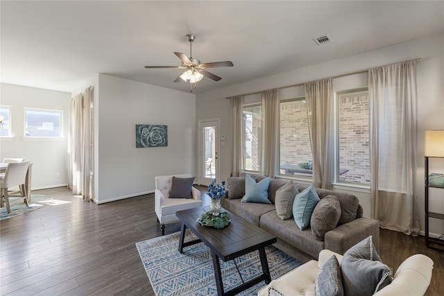 living room featuring ceiling fan, dark wood-type flooring, and a wealth of natural light