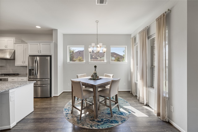 dining room featuring an inviting chandelier and dark hardwood / wood-style floors