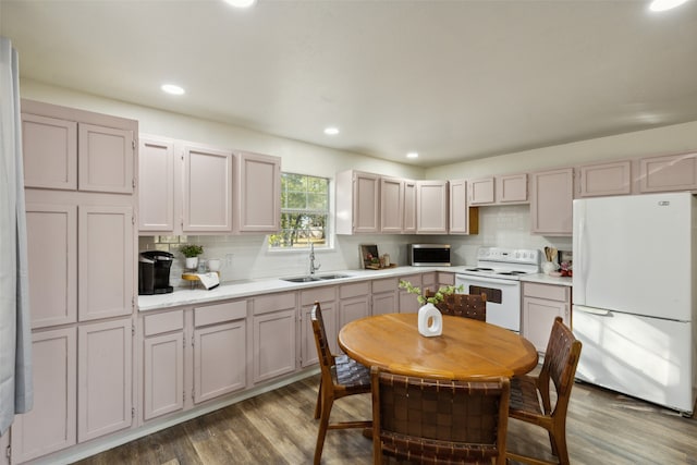 kitchen with hardwood / wood-style floors, white appliances, sink, and decorative backsplash