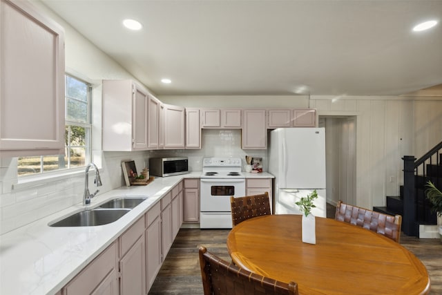 kitchen featuring sink, tasteful backsplash, dark hardwood / wood-style floors, light stone countertops, and white appliances