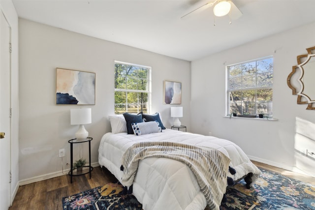 bedroom with multiple windows, ceiling fan, and dark hardwood / wood-style floors