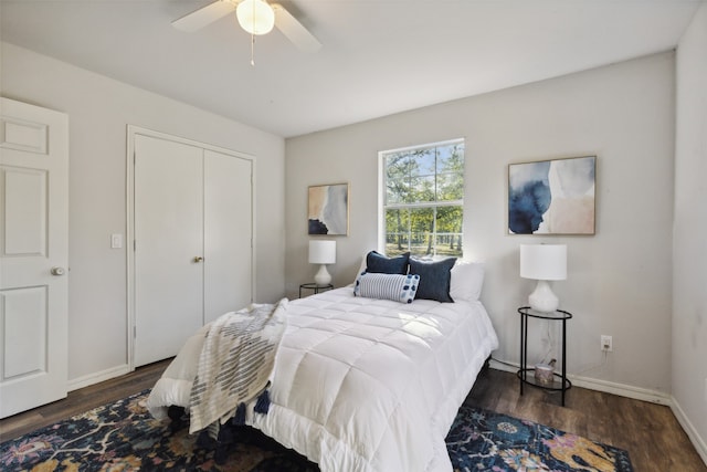 bedroom with dark wood-type flooring, ceiling fan, and a closet